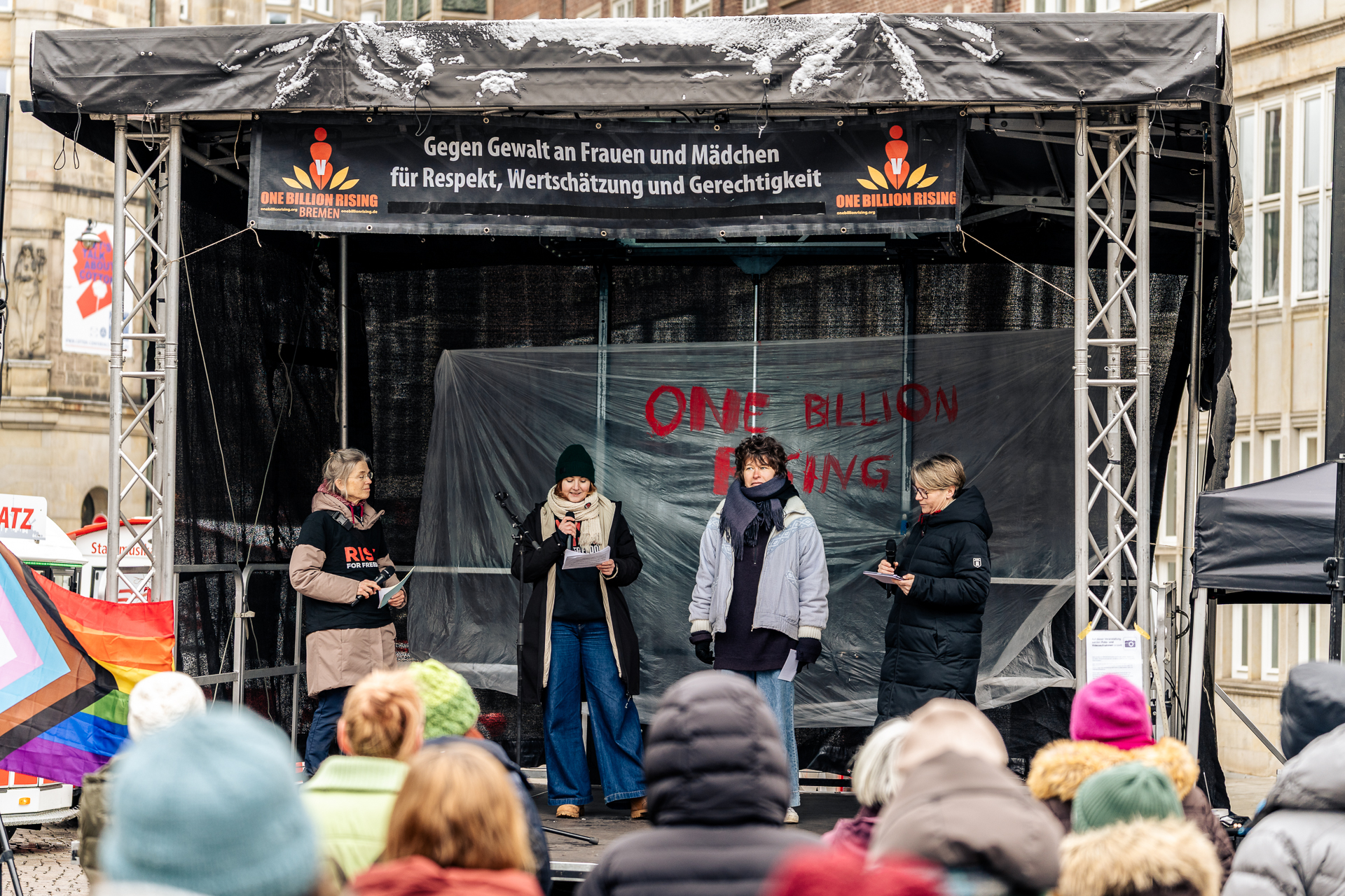 Vier Menschen stehen auf einer Buehne vor dem Publikum